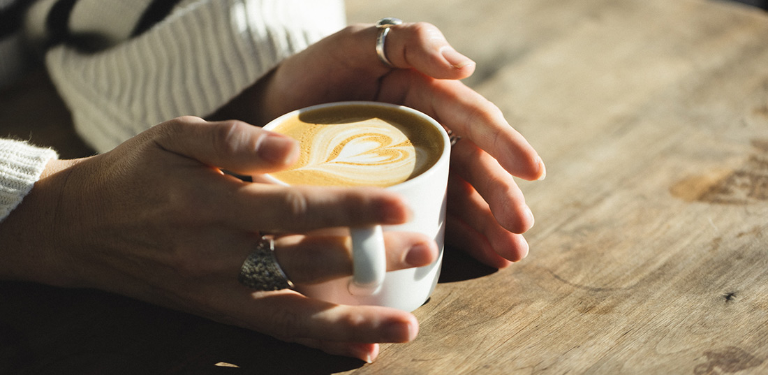 Coffee-Cup-Between-Hands-In-IQ-Cafe-Da-Bara-Bakery